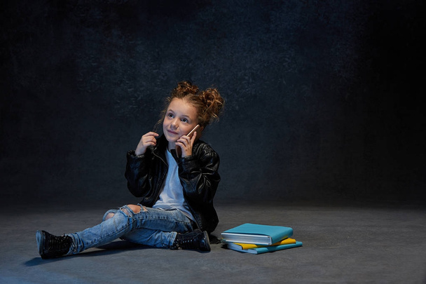 Little girl sitting with smartphone in studio - Foto, Imagem