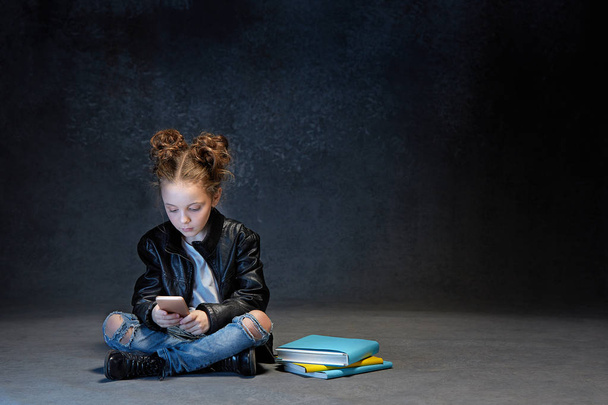 Little girl sitting with smartphone in studio - Фото, зображення