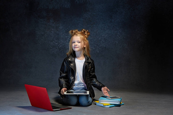 Little girl sitting with gadgets - Фото, зображення