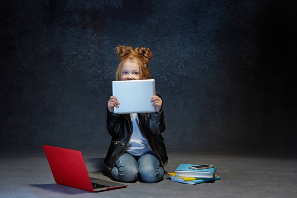 Little girl sitting with gadgets - Zdjęcie, obraz