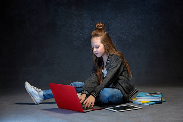 Little girl sitting with gadgets - Фото, зображення