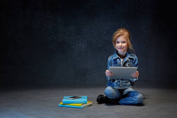 niña sentada con la tableta
 - Foto, imagen