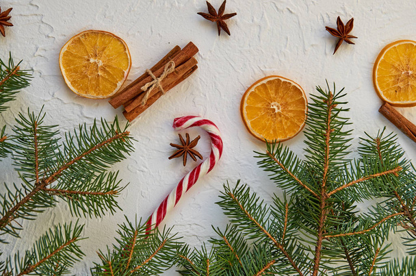 Kırmızı şeker koni ile beyaz arka plan üzerinde yıldız yakın çekim anason tarçın ile dekore edilmiş, portakal ve yeşil çam dalları kurutulmuş. Noel süslemeleri geleneksel baharatlar ile. Üstten Görünüm - Fotoğraf, Görsel