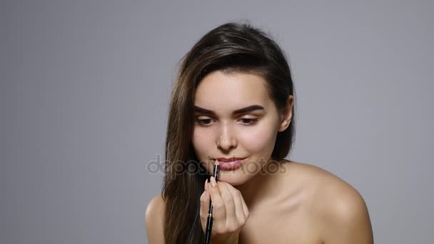 beautiful girl paints her lips - Imágenes, Vídeo