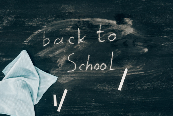 Top view of Back to school inscription on chalk board with cloth - Foto, imagen