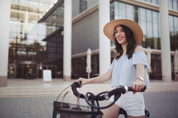 Portret z piękną, młodą kobietę, ciesząc się czas na rowerze w obszarze miejskim - Zdjęcie, obraz