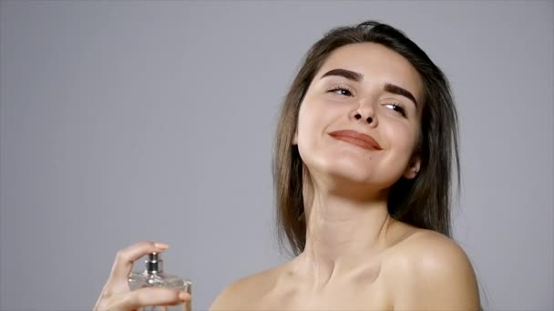 cute girl spraying some perfume on her body - Video