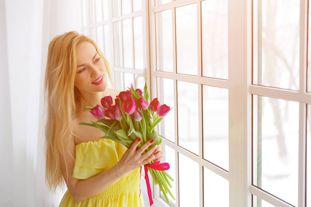 Портрет счастливой женщины с тюльпановым букетом
. - Фото, изображение