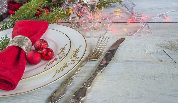 сервировка праздничного стола на рождественский ужин / белые тарелки, красная салфетка
 - Фото, изображение