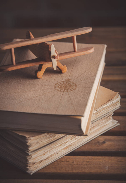 Vintage wooden airplane toy and old books - Fotó, kép