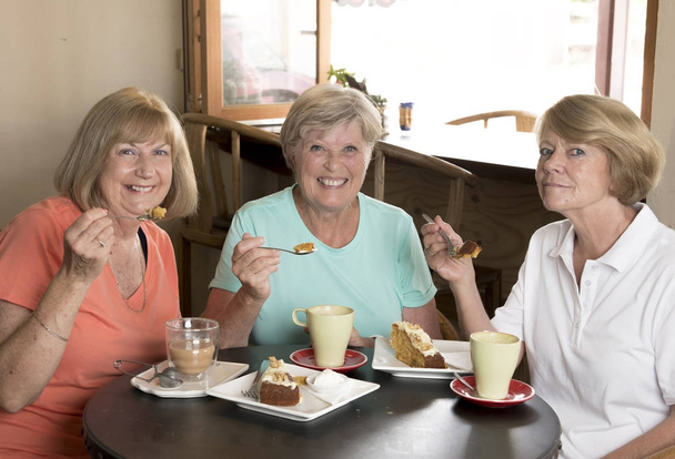 Grupa trzech przyjaciółek starszy dojrzałe kobiety piękne średnim wieku spotkanie na kawę i herbatę z ciasta w coffee shop - Zdjęcie, obraz