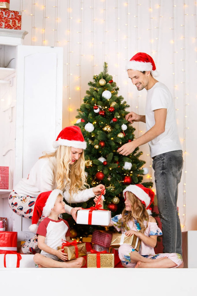 Happy family decorates Christmas pine - Fotoğraf, Görsel