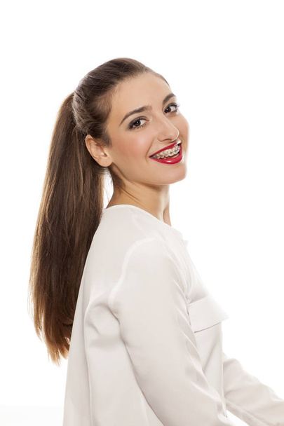 Side view of a beautiful young woman with ponytail on a white background - Fotografie, Obrázek