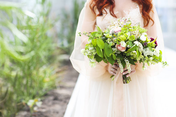 Young pretty bride with bouquet - Fotó, kép
