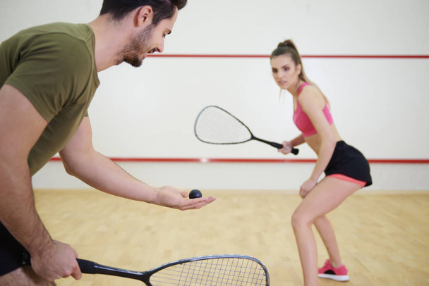 Athletic couple playing squash together - Fotoğraf, Görsel