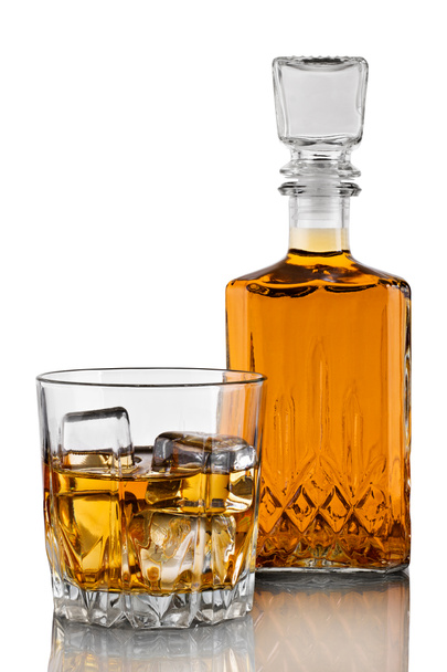 Decantador, un vaso de whisky con hielo sobre un fondo blanco con reflejo
 - Foto, imagen