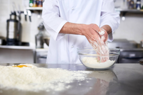 Chef making dough from flour and raw eggs on table - Foto, Bild