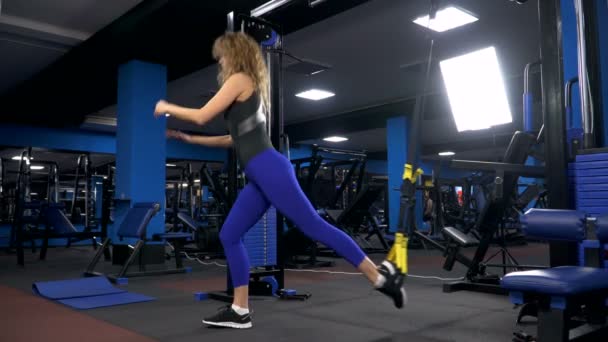 Jonge aantrekkelijke vrouw abs crossfit schuine opleiding met fitness bandjes in de sportscholen studio kern. TRX® - Video
