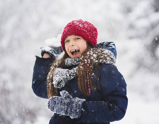 Winter. Cute little girl having fun outdoors - Foto, Imagen