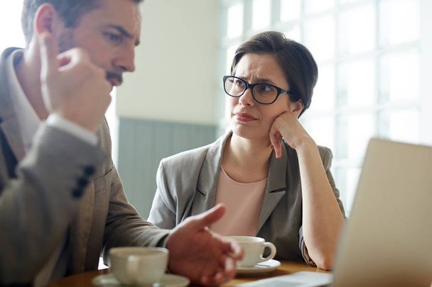 Retrato de dois empresários confusos, homem e mulher, resolvendo o problema do trabalho durante a reunião no café
 - Foto, Imagem