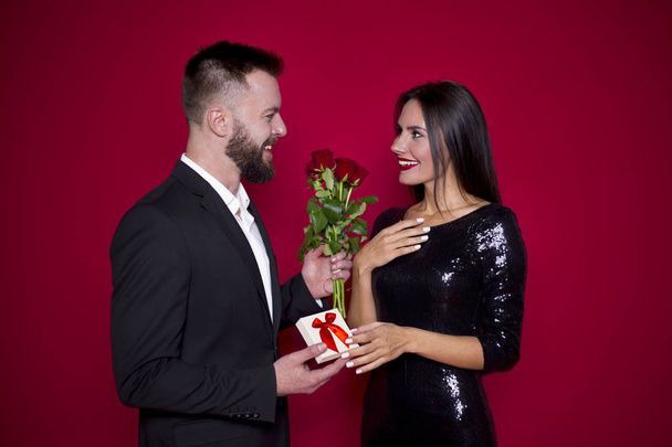 My love is for you. Beautiful young couple in love on a red background. Valentine's Day. Women's Day. March 8 - Zdjęcie, obraz