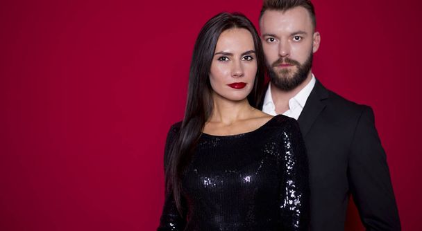 Beautiful couple in black luxury dress on a red background. Valentine's Day. Women's Day. March 8 - Fotoğraf, Görsel