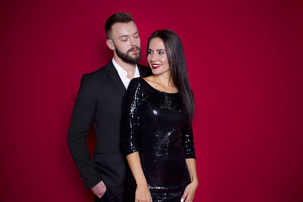 Beautiful couple in black luxury dress on a red background. Valentine's Day. Women's Day. March 8 - Foto, Imagem