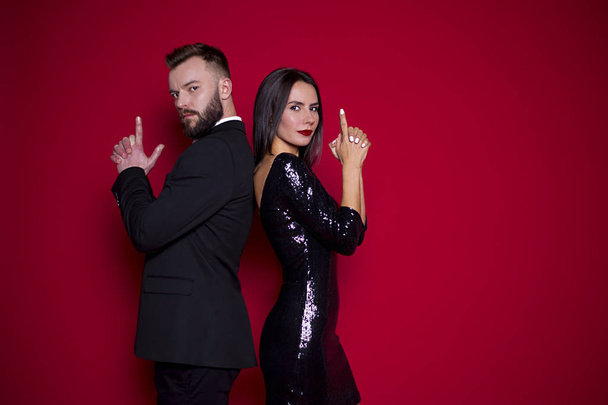 Beautiful couple in black luxury dress on a red background. Valentine's Day. Women's Day. March 8 - Photo, Image