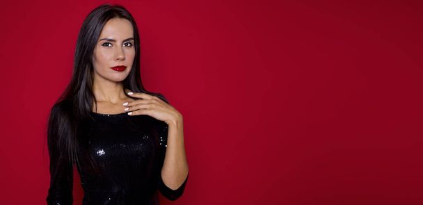 Close up Portrait of a beautiful woman with a beautiful make-up in a black dress on a red background. St. Valentine's Day or Women's Day. March 8. Fashion Concept - Valokuva, kuva