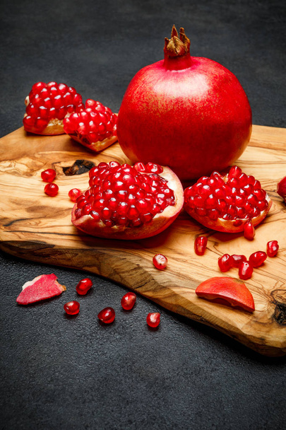 Pomegranate and seeds close-up on dark concrete background - Photo, Image