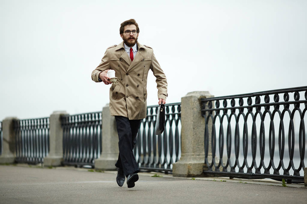 Stylish man with drink and briefcase hurrying for interview or appointment - Photo, Image