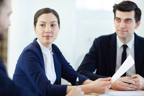 Businesswoman with document listening to co-worker - Photo, Image