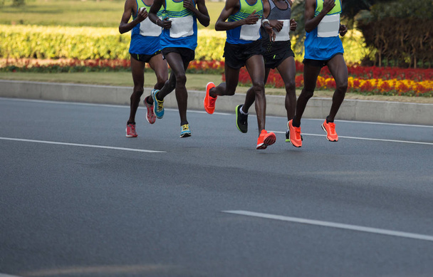 ноги марафонцев, бегущих по городской дороге
 - Фото, изображение