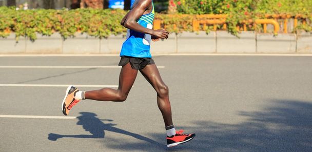 piernas del corredor de maratón corriendo por la carretera de la ciudad
 - Foto, imagen