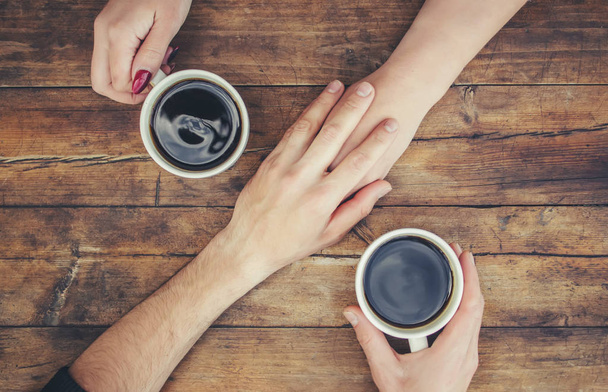 Tasses avec un café dans les mains des hommes et des femmes. Concentration sélective. - Photo, image