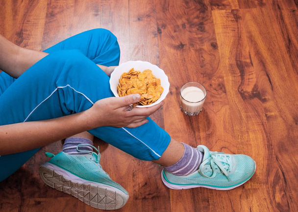 Woman sitting on the floor with healthy breakfast - Foto, Imagem