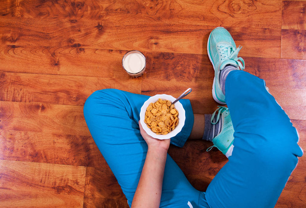 Woman sitting on the floor with healthy breakfast - Foto, Imagem