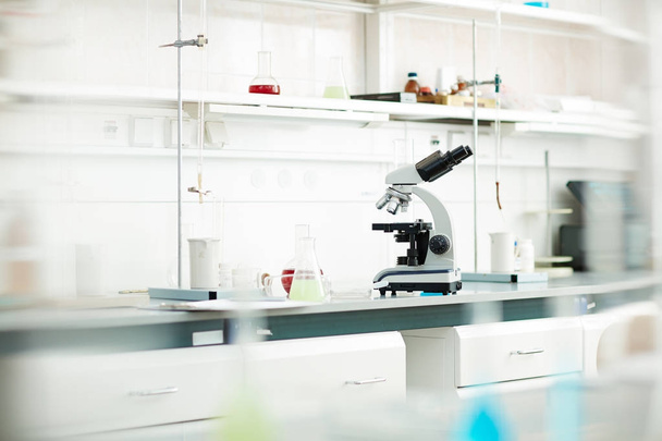 Background image of various equipment and microscope on table in empty laboratory - Fotoğraf, Görsel
