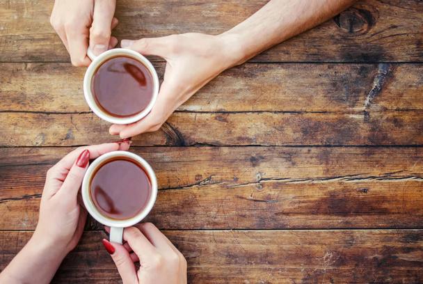 Чашки чаю в руках чоловіків і жінок. Вибірковий фокус
. - Фото, зображення
