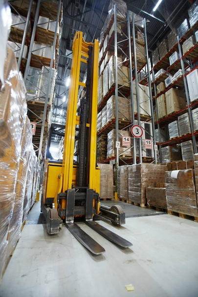 Forklift in aisle of large-scale warehouse - Photo, Image
