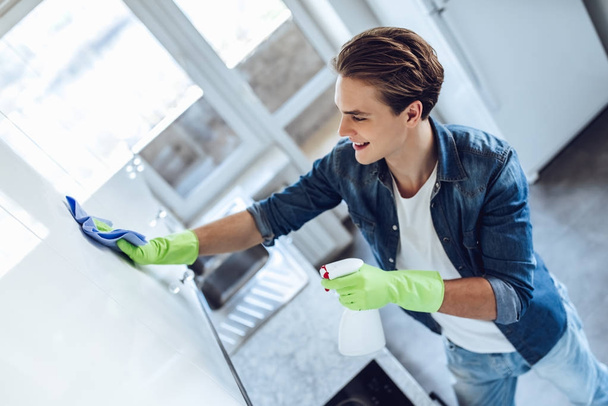 Young man is doing cleaning at home - Fotoğraf, Görsel