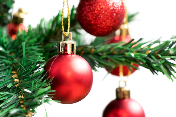 Kulička červená dekorace na zelený vánoční stromeček s bílým pozadím - Fotografie, Obrázek