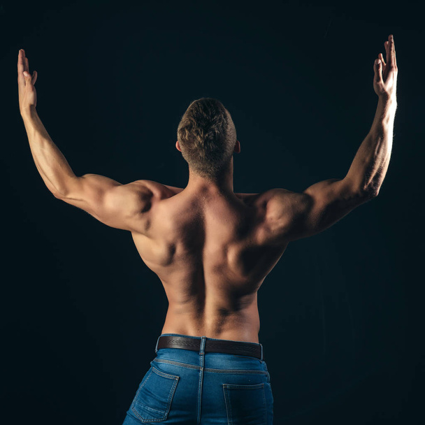 Bodybuilder man show biceps, triceps with raised hands - Фото, зображення