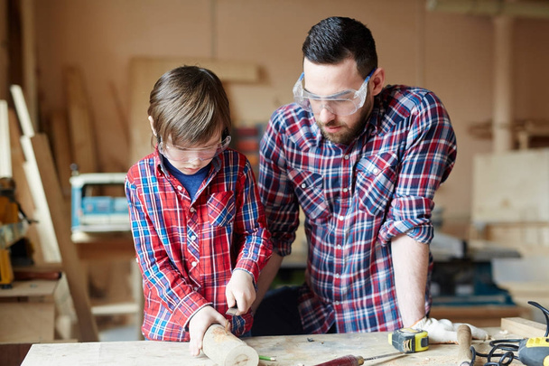 Creative man and little boy wood crafting together - Photo, Image