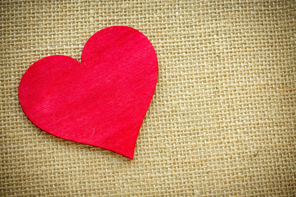 Corazón aislado sobre un tejido de arpillera. Día de San Valentín y concepto de amor
 - Foto, imagen