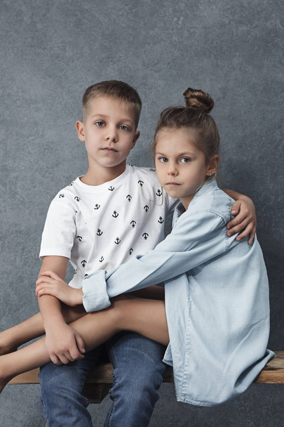 Um retrato de menina e um menino no fundo cinza
 - Foto, Imagem