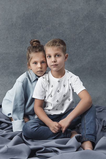 Портрет маленької дівчинки і хлопчика на сірому фоні
 - Фото, зображення