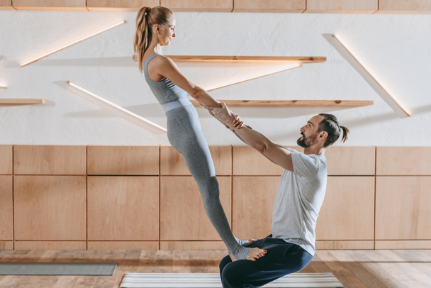 middle aged couple practicing yoga together at training class - Foto, Imagem