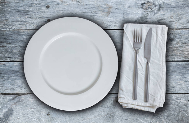 Empty plate and cutlery on grayed wood - Zdjęcie, obraz