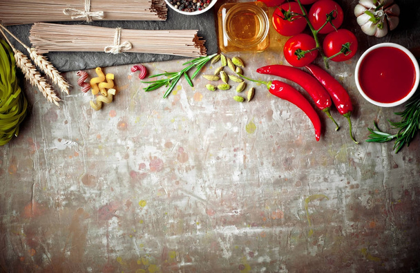 Makarna sebze ve eski bir arka plan üzerinde mutfak aksesuarları ile bir kompozisyon içinde - Fotoğraf, Görsel